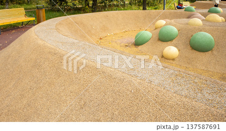 Playground hemispheres on sand beige rubber surface, safe EPDM play area Playground hemispheres on sand beige rubber surface, safe EPDM play area 137587691