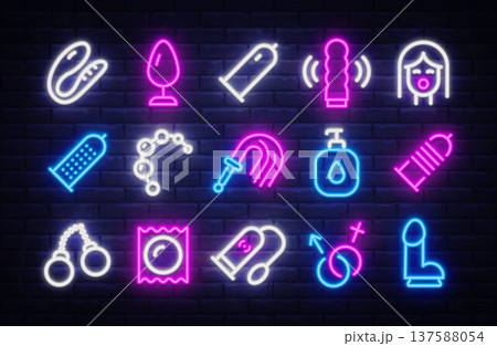 Neon icon set with adult shop symbols glowing in pink, blue, and white on dark brick wall. Bright outlines highlight toys, protection, and playful accessories. 137588054
