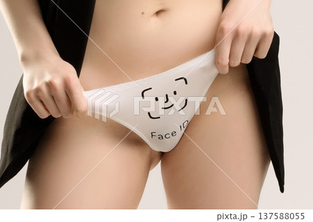 Woman holds up white panties with 'Face ID' on them in studio Woman holds up white panties with 'Face ID' on them in studio 137588055