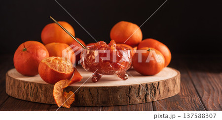 Fresh Tangerines with Jam Glass on dark wooden Background. Rustic Gourmet Composition Fresh Tangerines with Jam Glass on dark wooden Background. Rustic Gourmet Composition 137588307
