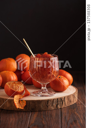 Fresh Tangerines with Jam Glass on dark wooden Background. Rustic Gourmet Composition Fresh Tangerines with Jam Glass on dark wooden Background. Rustic Gourmet Composition 137588308