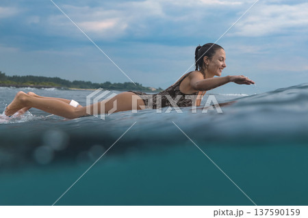 Eager Young Lady Balancing On Surfboard During Sunrise Peaceful Ocean 137590159