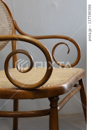 Elegant wooden chair with intricate curved armrest design showcasing craftsmanship in furniture making 137590366