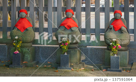 Sakata, Yamagata, japan - Oct 5 2024, A close-up view of three stone statues of Jizo patron deity of children and travelers, wearing red caps and bibs, on grounds of Jichi-In temple, Sakata, Japan Sakata, Yamagata, japan - Oct 5 2024, A close-up view of three stone statues of Jizo patron deity of children and travelers, wearing red caps and bibs, on grounds of Jichi-In temple, Sakata, Japan 137591064
