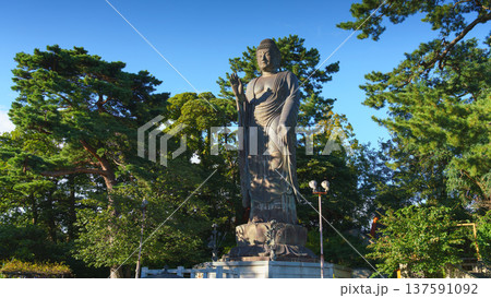 Sakata, Yamagata, japan - Oct 5 2024, A panoramic view of the giant Great Buddha statue at Jichi-In Temple, with trees in the background, at daytime, Sakata, Japan 137591092