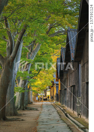 Sakata, Yamagata, japan - Oct 5 2024, vertical view of Sankyo Soko Storehouse with an alley of trees nearby, at sunset, without people, Sakata, Japan Sakata, Yamagata, japan - Oct 5 2024, vertical view of Sankyo Soko Storehouse with an alley of trees nearby, at sunset, without people, Sakata, Japan 137591124