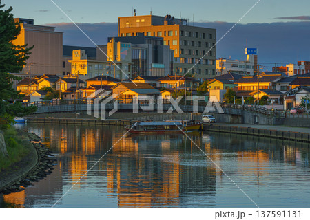 Sakata, Yamagata, japan - Oct 5 2024, A panoramic view of the Niida River with wooden pleasure boats and residential buildings in background, at sunset, Sakata, Japan 137591131