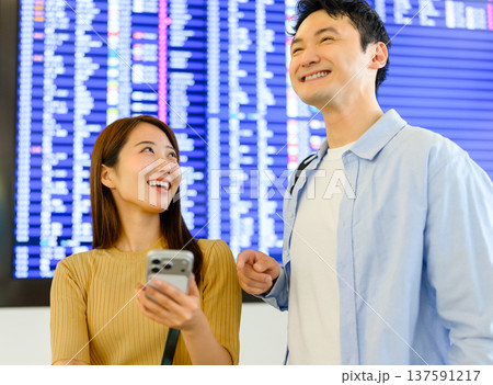 空港で案内表示を見る二人 ■撮影協力：関西国際空港（KIX） 137591217