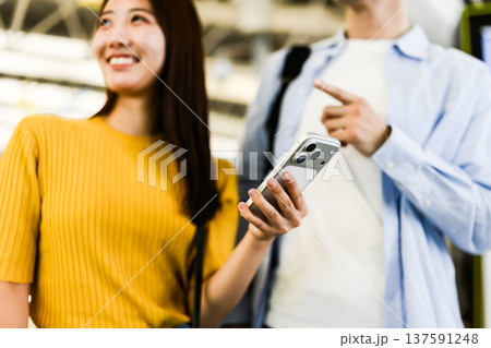 空港でスマホを操作する男女 137591248