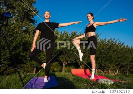 Inspiring yoga practice under a clear blue sky near lush trees 137592139