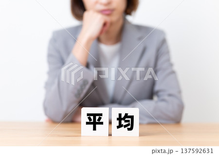 平均のブロックと悩むスーツ姿のミドル女性 平均のブロックと悩むスーツ姿のミドル女性 137592631