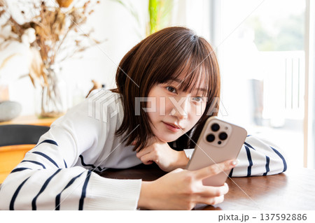 リビングでスマホを見る女性 137592886