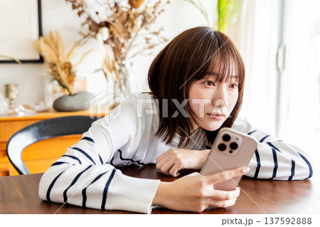 リビングでスマホを見る女性 リビングでスマホを見る女性 137592888