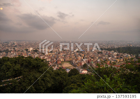 The cityscape of Kathmandu the capital city of Nepal seen from Swayambhunath stupa at evening. The city located in the bowl-shaped Kathmandu Valley of central Nepal. The cityscape of Kathmandu the capital city of Nepal seen from Swayambhunath stupa at evening. The city located in the bowl-shaped Kathmandu Valley of central Nepal. 137593195