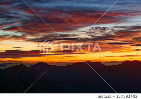 北アルプス・双六岳から見る朝焼け雲と餓鬼岳稜線 137593402