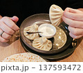 Hands holding khinkali dumplings 137593472