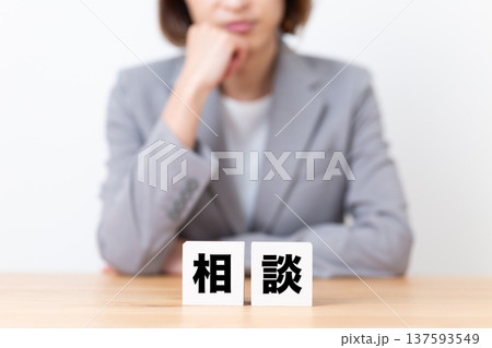 相談のブロックと悩むスーツ姿のミドル女性 137593549