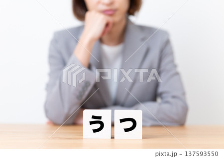 うつのブロックと悩むスーツ姿のミドル女性 うつのブロックと悩むスーツ姿のミドル女性 137593550