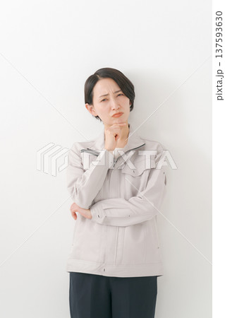 悩む作業着の女性 137593630