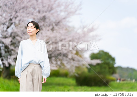 桜の木の前でポージングする若い女性　ライフスタイルイメージ 137595318