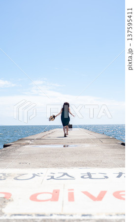 海と堤防に立つ女性 海と堤防に立つ女性 137595411