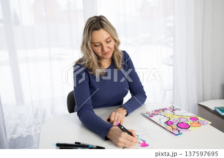 Woman in Blue Shirt Creating Neurographic Art for Mental Wellness at Table Woman in Blue Shirt Creating Neurographic Art for Mental Wellness at Table 137597695
