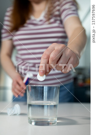 Dropping Effervescent Tablet Into Water for a Refreshing Drink 137597696