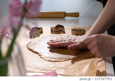Hands Pressing Dough for Festive Easter Bunny and Gingerbread Cookie Treats 137597701