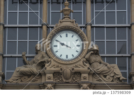 Historic clock tower facade at railway station featuring classical sculptures architectural design 137598309