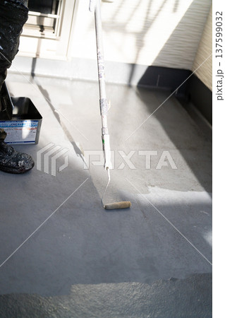 ベランダの防水塗装メンテナンス：長柄ローラーで防水材を塗布する作業員　手元 137599032