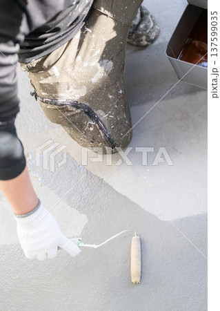 ベランダの防水塗装メンテナンス:長柄ローラーで防水材を塗布する作業員 手元 ベランダの防水塗装メンテナンス:長柄ローラーで防水材を塗布する作業員 手元 137599035