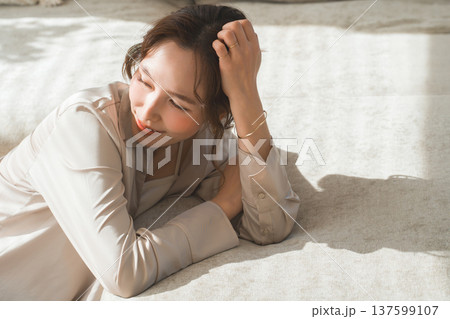 日の当たるソファでうたた寝する女性 137599107