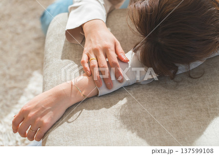 日の当たるソファでうたた寝する女性 137599108