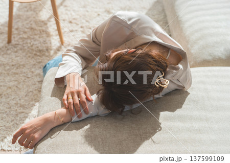 日の当たるソファでうたた寝する女性 137599109