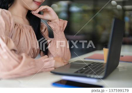 Adult Asian woman focused working laptop professional thinking business ideas contemplating solutions modern office cafe setting digital connection remote work productivity Adult Asian woman focused working laptop professional thinking business ideas contemplating solutions modern office cafe setting digital connection remote work productivity 137599179