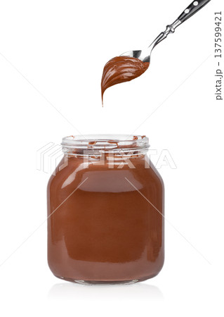 Chocolate spread on fork above jar isolated on white background Chocolate spread on fork above jar isolated on white background 137599421