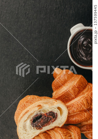 Chocolate croissant with creamy chocolate spread and pastry on dark background with copy space 137599445