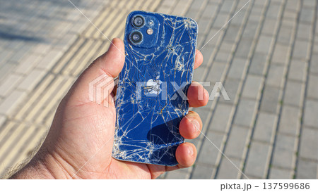 Alanya, Antalya, Turkey - Jan 19 2023, broken Apple iPhone in hand on the background of the sidewalk Alanya, Antalya, Turkey - Jan 19 2023, broken Apple iPhone in hand on the background of the sidewalk 137599686