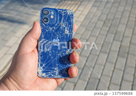 Alanya, Antalya, Turkey - Jan 19 2023, broken Apple iPhone in hand on the background of the sidewalk Alanya, Antalya, Turkey - Jan 19 2023, broken Apple iPhone in hand on the background of the sidewalk 137599688