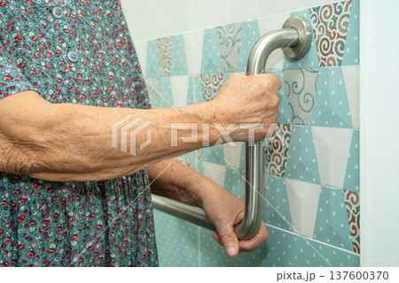 Asian elderly woman patient use toilet bathroom handle security in nursing hospital, healthy strong medical. 137600370