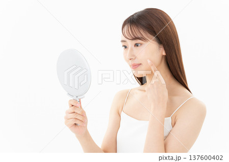 白背景でスキンケアをする女性のビューティーイメージ 白背景でスキンケアをする女性のビューティーイメージ 137600402