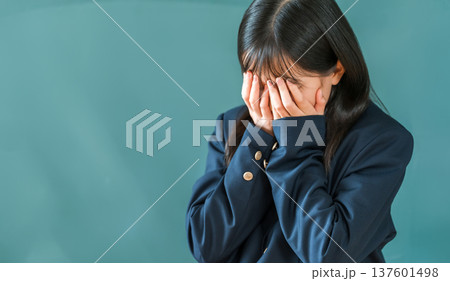 学校の黒板の前で泣く制服姿の小学生,中学生,高校生の女の子 137601498