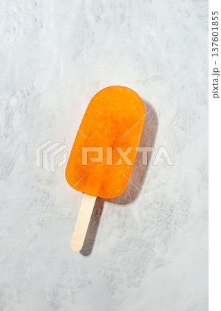 Orange ice cream lying on an gray background. Orange ice cream lying on an gray background. 137601855