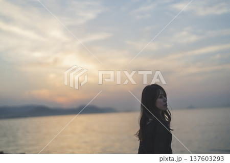 夕暮れの海を眺める女性 137603293