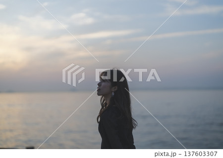 夕暮れの海を眺める女性 137603307