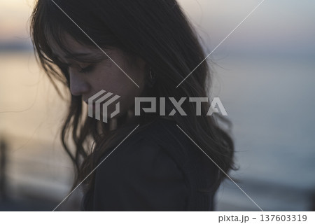 夕暮れの海を眺める女性 137603319