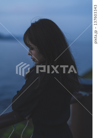 夕暮れの海を眺める女性 137603343