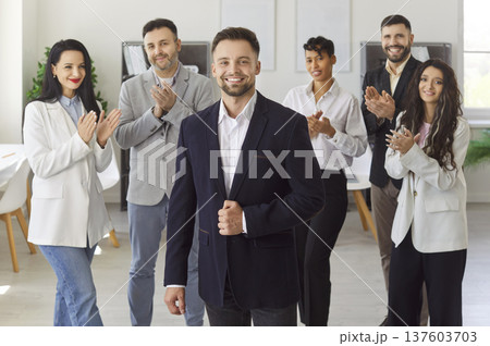 Happy young business man looking at camera and smiling in office. Leadership and success concept Happy young business man looking at camera and smiling in office. Leadership and success concept 137603703