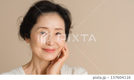 ベージュ背景に佇む美肌のミセス（広いコピースペース） 137604116