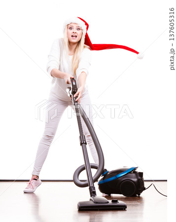 Girl in santa helper hat with vacuum cleaner Girl in santa helper hat with vacuum cleaner 137605316
